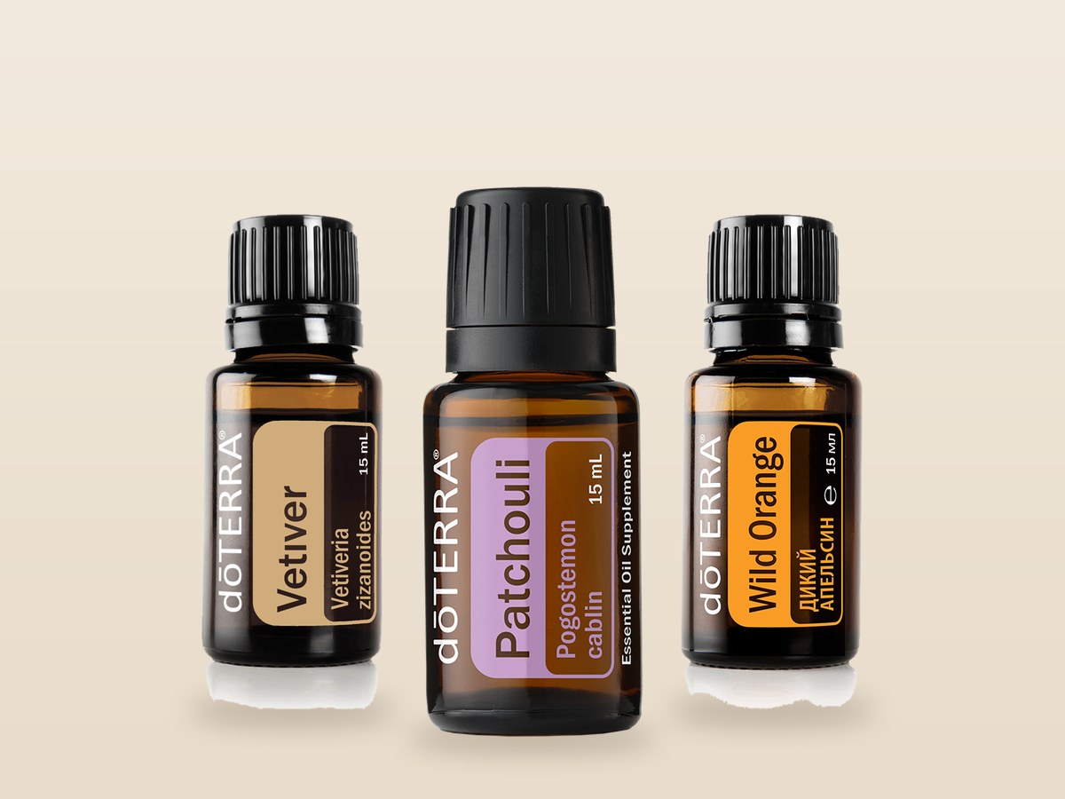 Флаконы эфирных масел doTERRA ветивер, пачули и дикий апельсин по 15 мл на бежевом фоне, официальные фото doTERRA